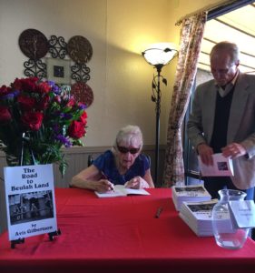 Elderly woman signing booklets